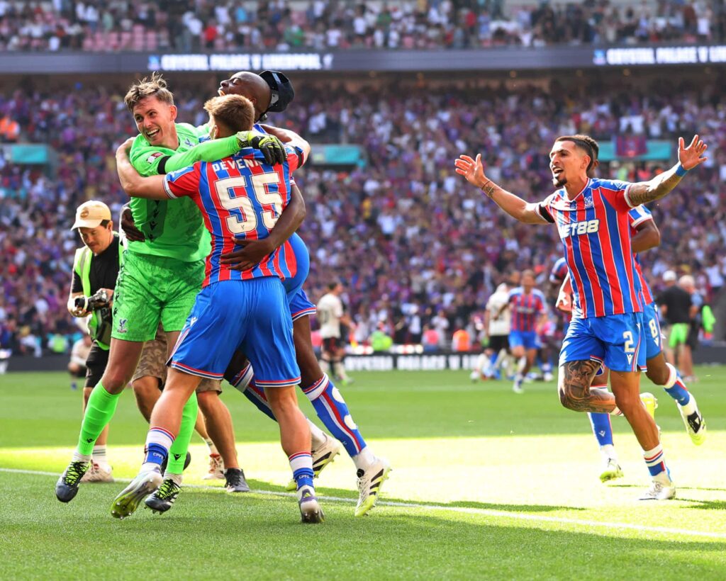 Crystal Palace players celebrating a dramatic victory against Liverpool on the football field.