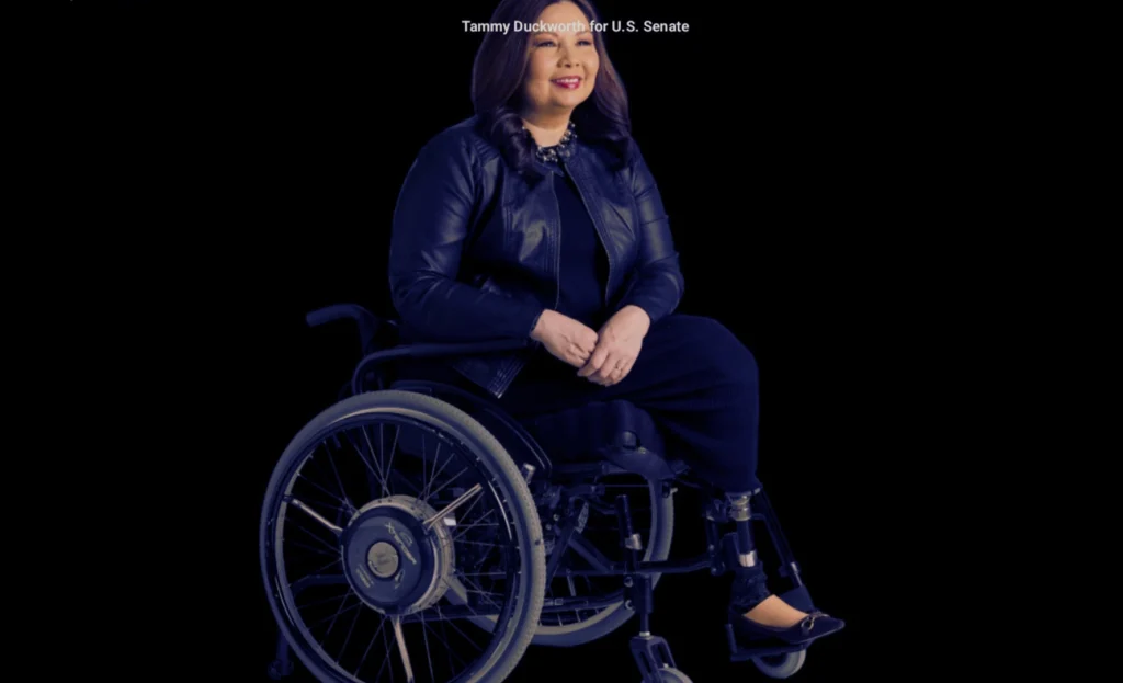 Tammy Duckworth speaking at a public event, wearing a blazer, confidently addressing the audience.